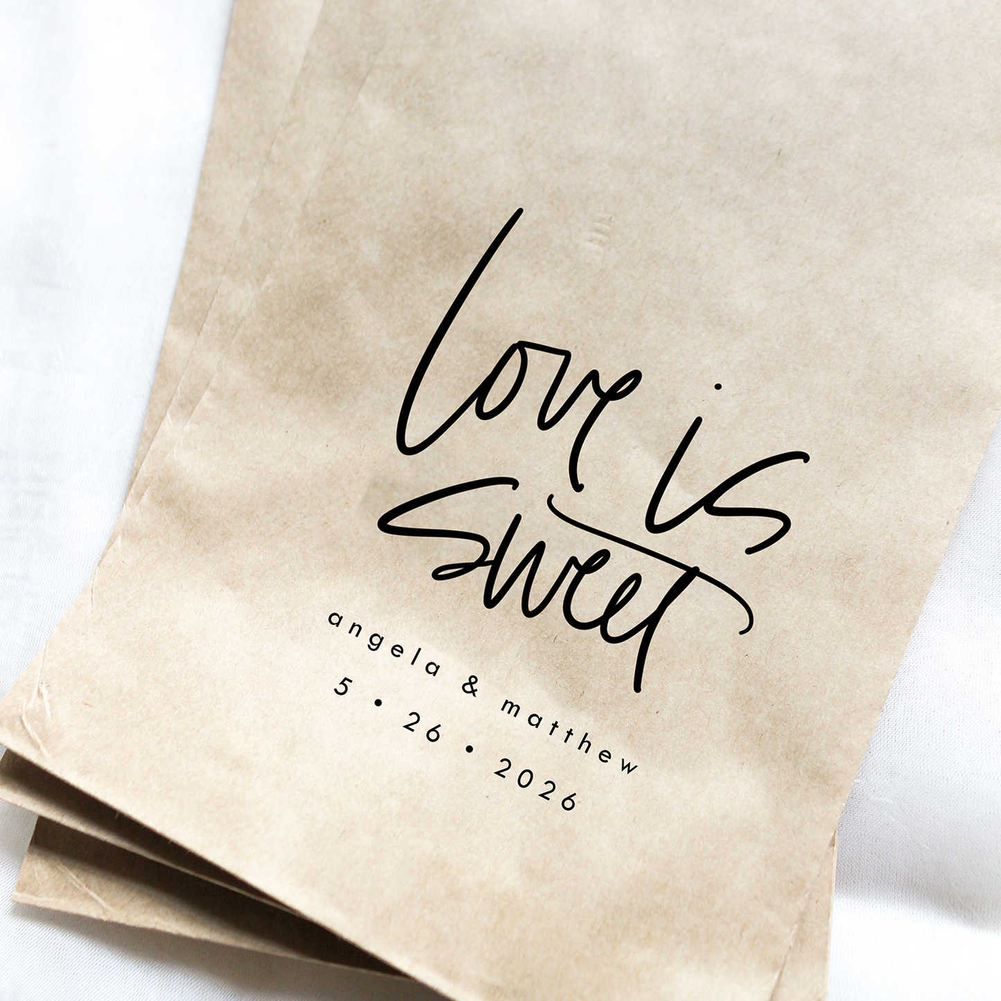 Kraft paper bags with 'Love is Sweet' text on a white background