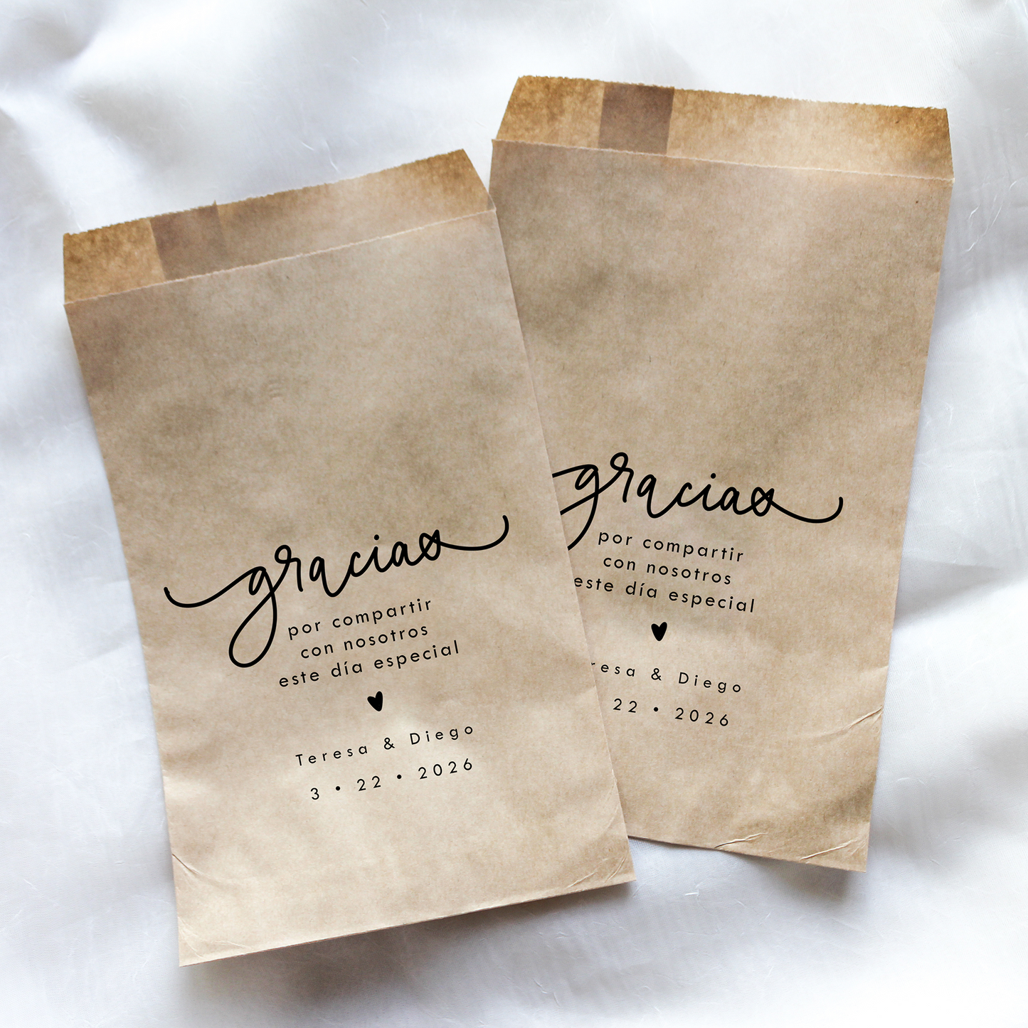 Two brown paper bags with 'gracias' text on a white background