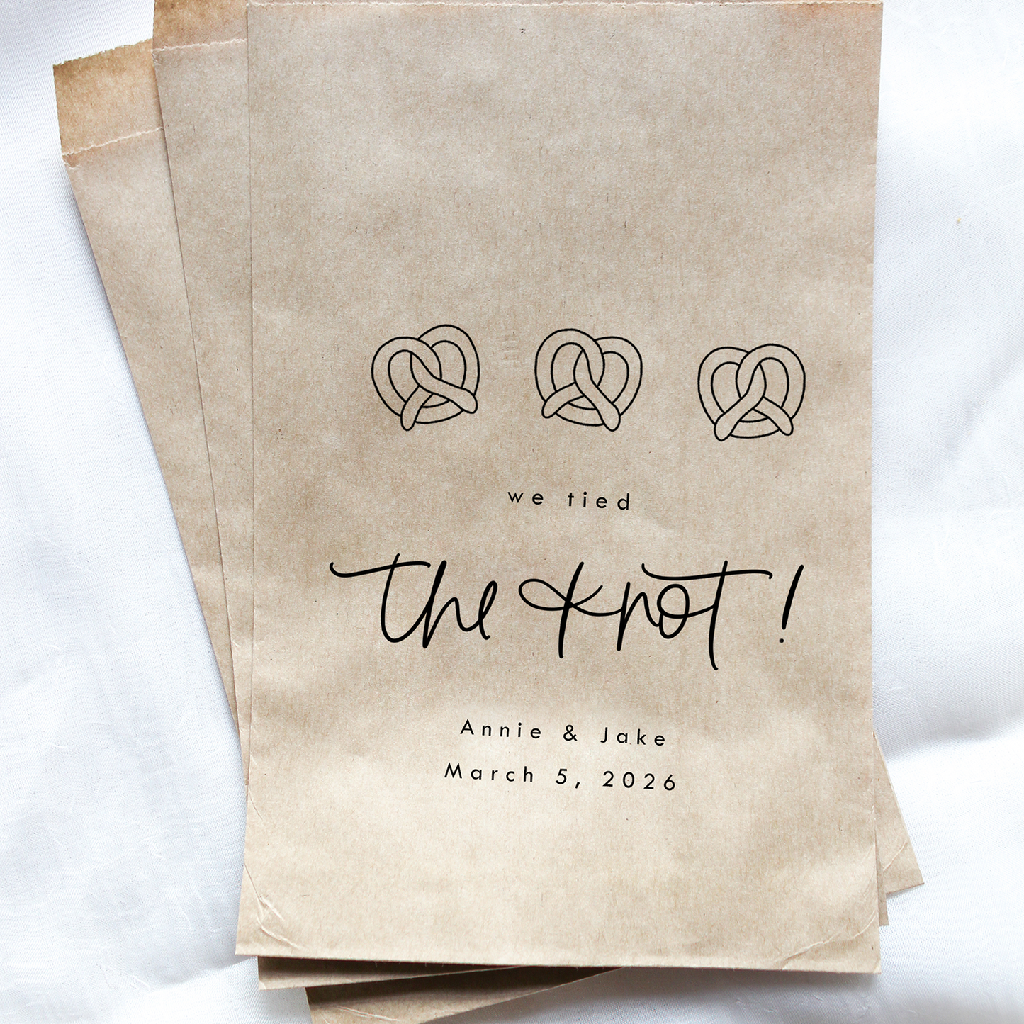Kraft paper bags with 'we tied the knot' text and design on a white background