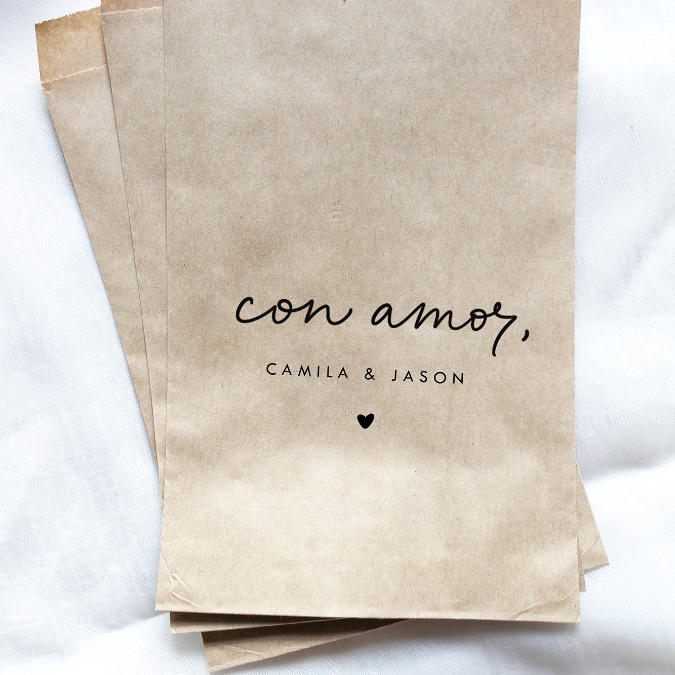 Stack of brown paper bags with 'con amor' text on a white background
