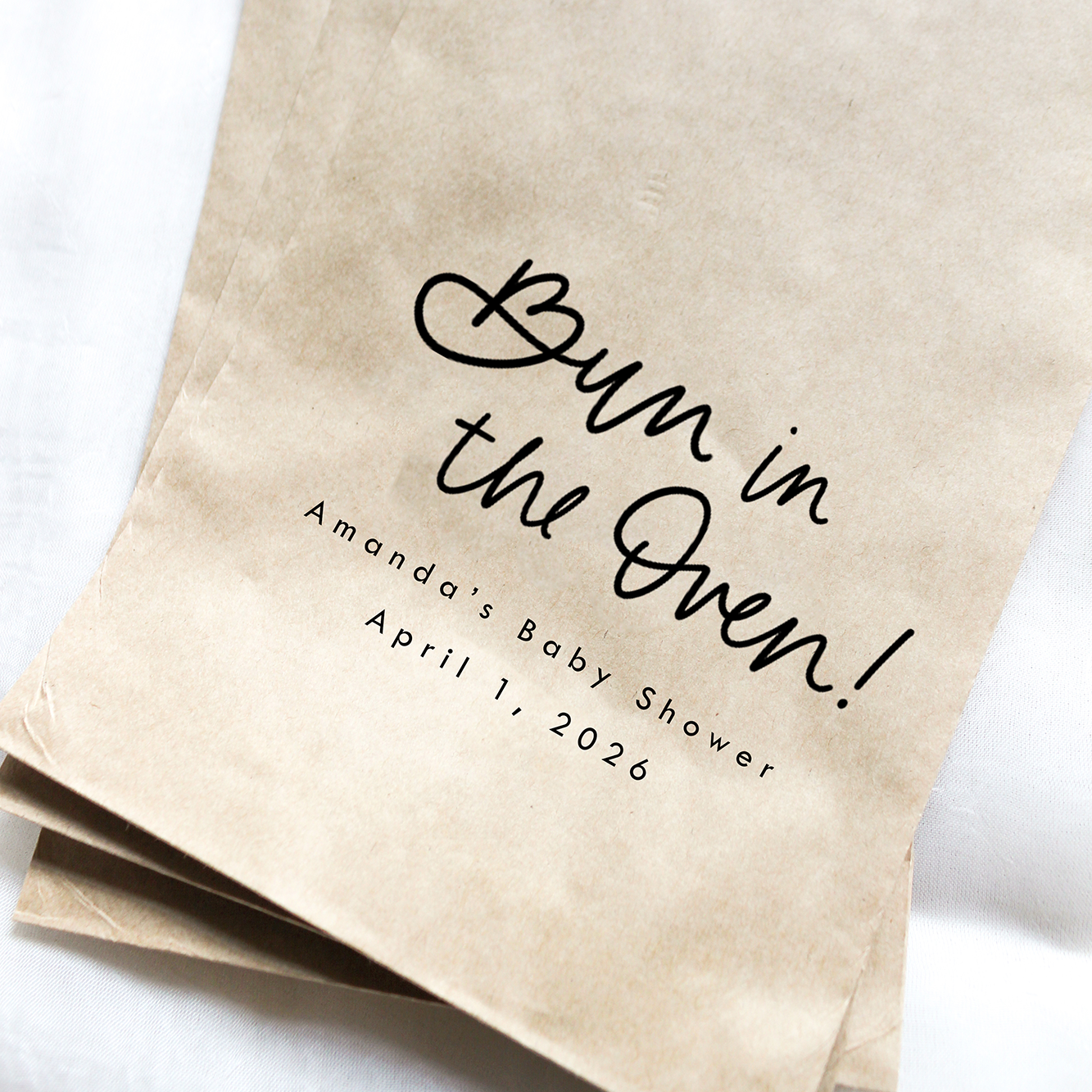Three brown paper bags with 'Bun in the Oven!' text on a white background