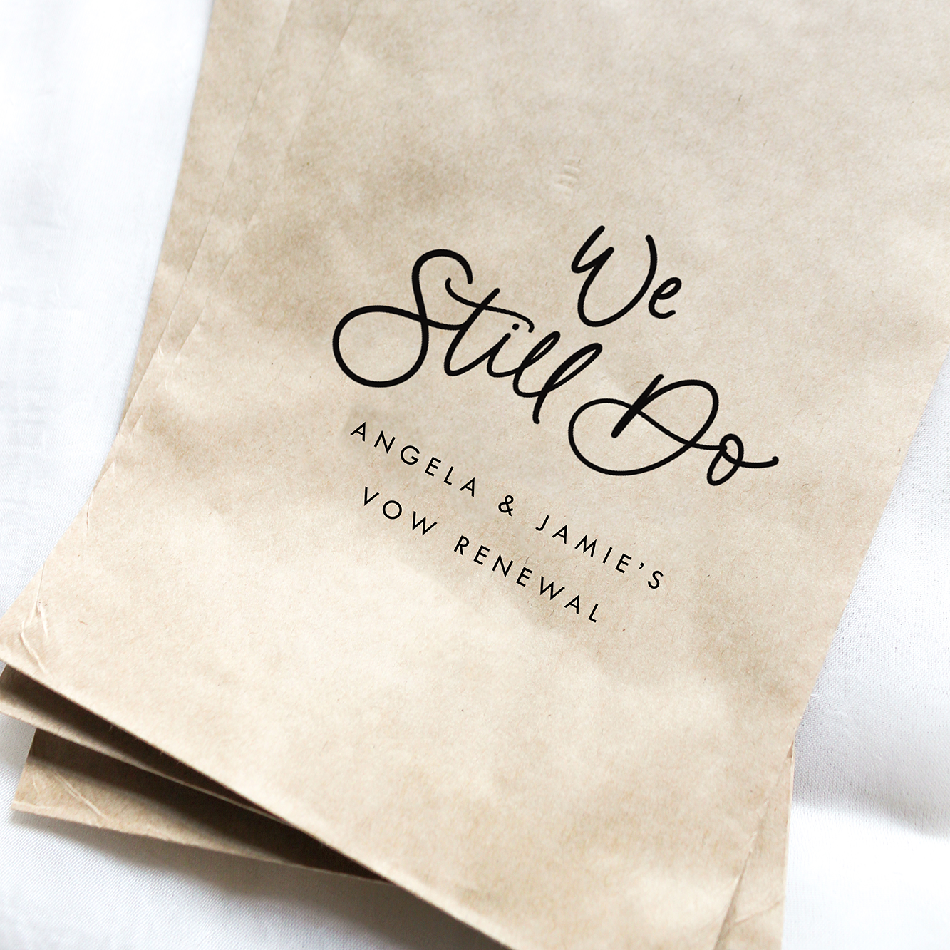 Brown paper bags with 'We Still Do' text on a white background