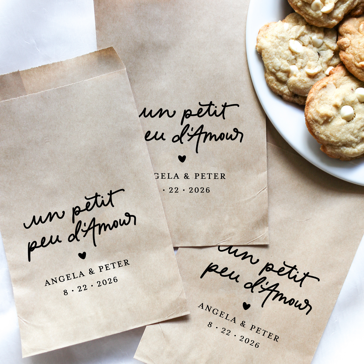 Kraft paper bags with personalized text on a white surface with cookies.