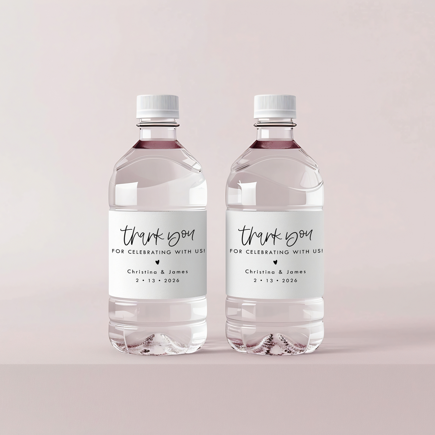 Two water bottles with personalized labels on a light pink background
